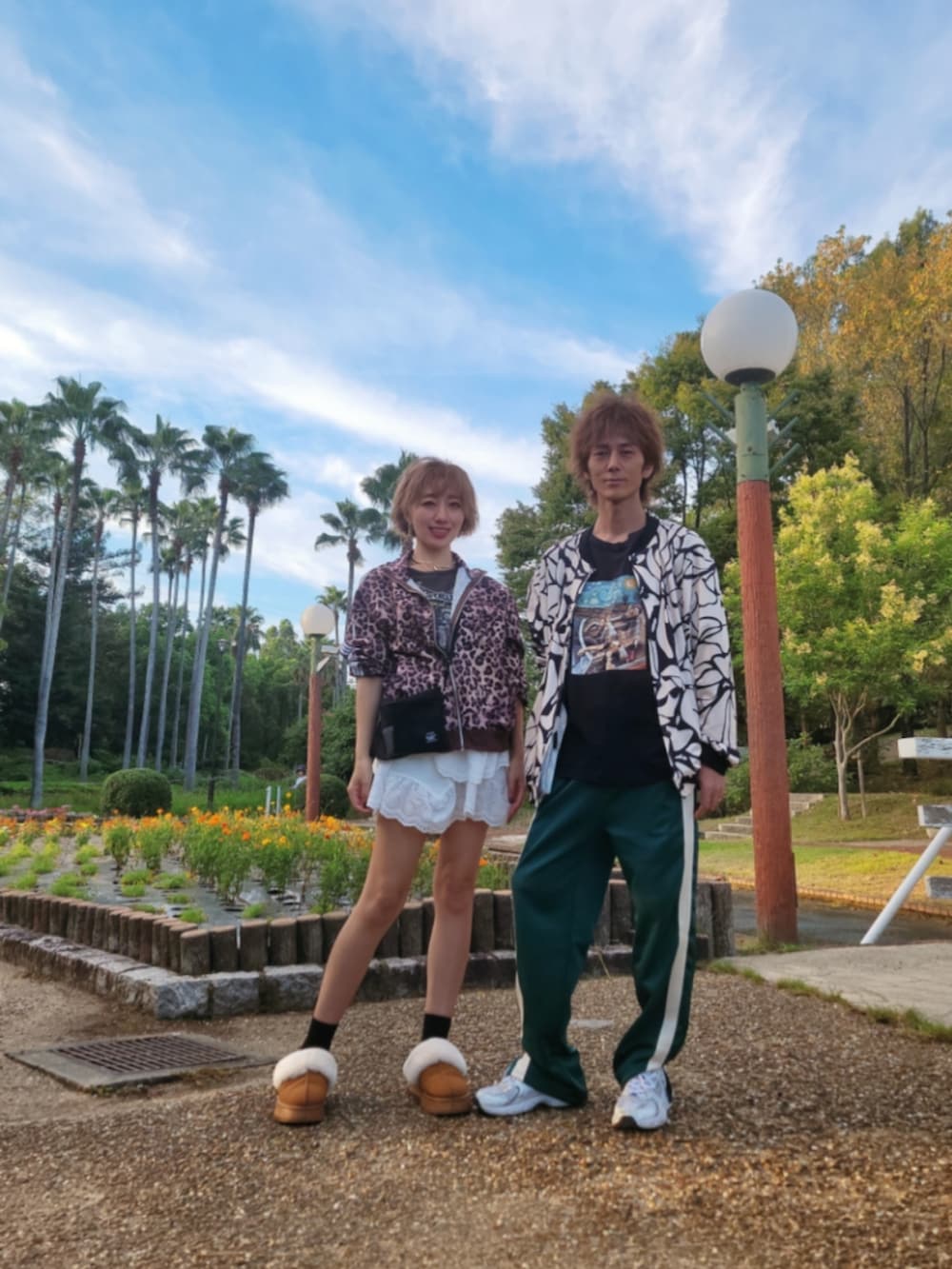 グリーン系のパンツ、ホワイト系のスニーカー、ブラウン系のナイロンジャケットを着用したレディースの秋コーディネートの2枚目の写真