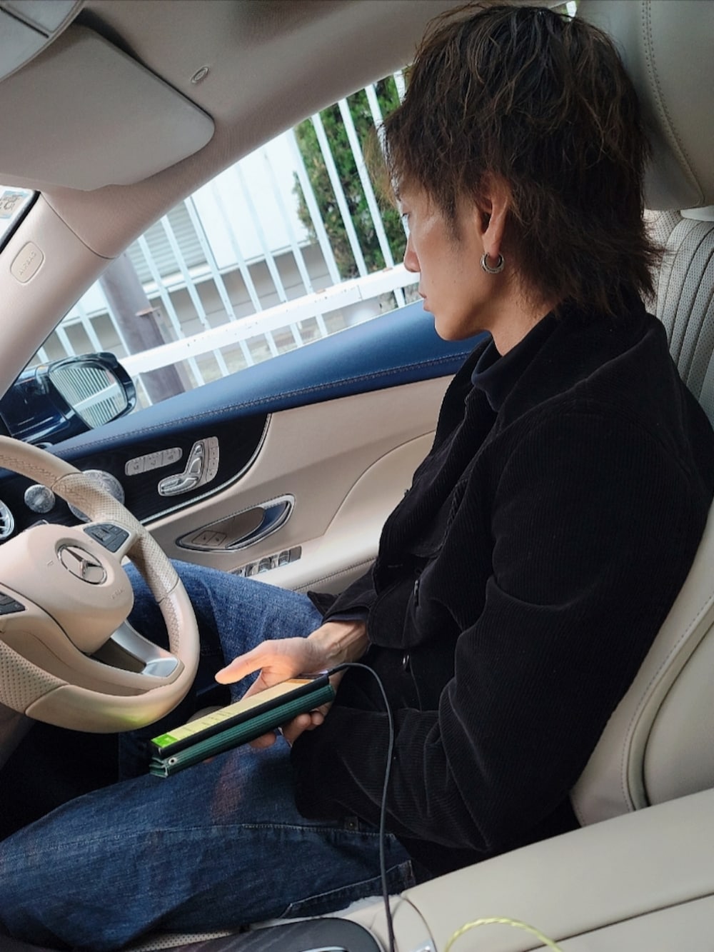 ブルー系のデニムパンツ、ベージュ系のブーツ、ブラック系のピーコートを着用したレディースの冬コーディネートの3枚目の写真