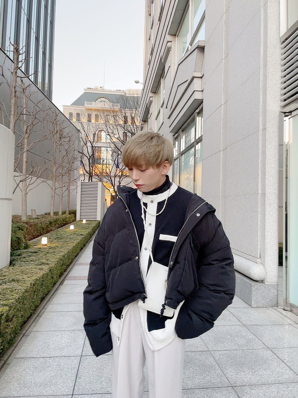 ブラック系のスニーカー、ブラック系のダウンジャケット/コート、ブラック系のカーディガン/ボレロを着用したメンズの冬コーディネートの2枚目の写真