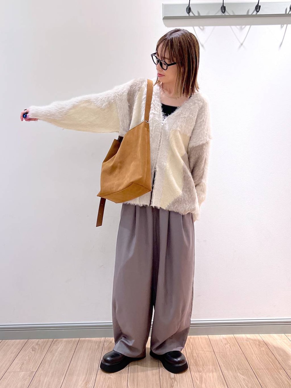 ブラック系のTシャツ/カットソー、ホワイト系のカーディガン/ボレロ、グレー系のその他パンツを着用したレディースの秋コーディネートの4枚目の写真