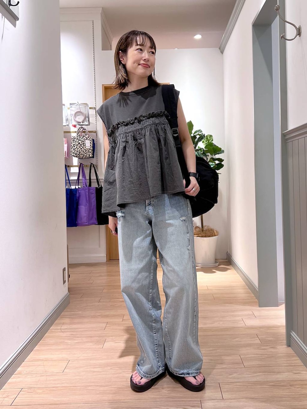 ブラック系のショルダーバッグ、ブルー系のデニムパンツ、グレー系のTシャツ/カットソーを着用したレディースの夏コーディネートの4枚目の写真