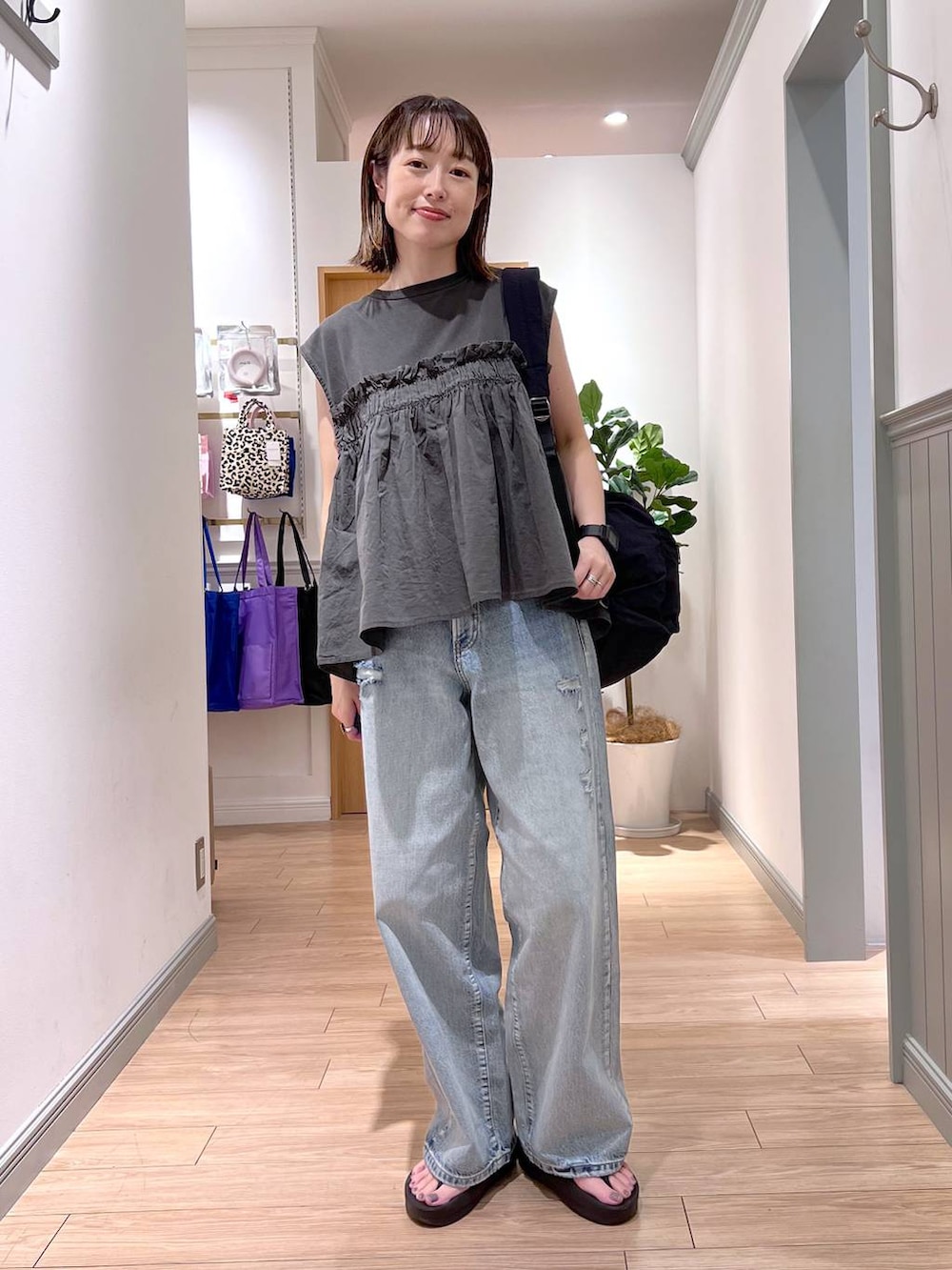 ブラック系のショルダーバッグ、ブルー系のデニムパンツ、グレー系のTシャツ/カットソーを着用したレディースの夏コーディネートの3枚目の写真