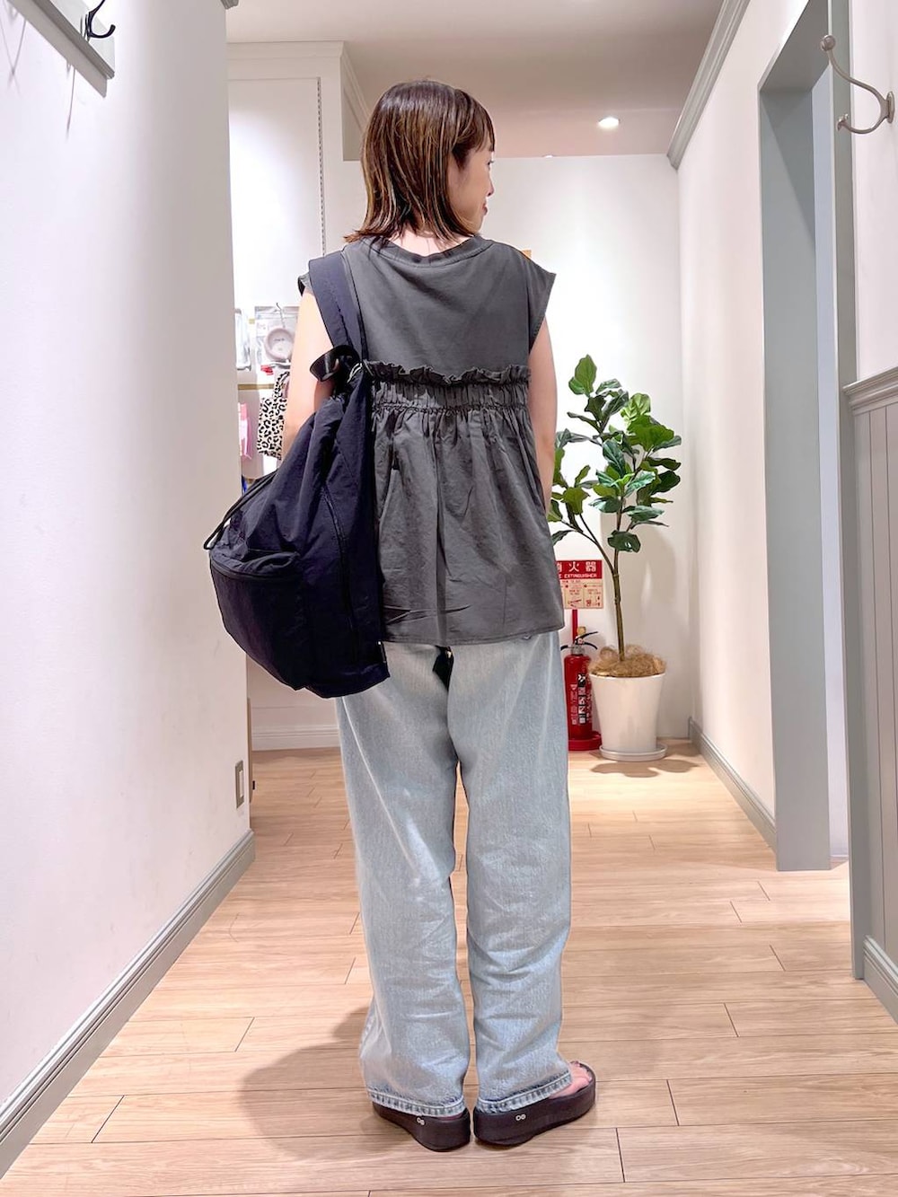 ブラック系のショルダーバッグ、ブルー系のデニムパンツ、グレー系のTシャツ/カットソーを着用したレディースの夏コーディネートの5枚目の写真