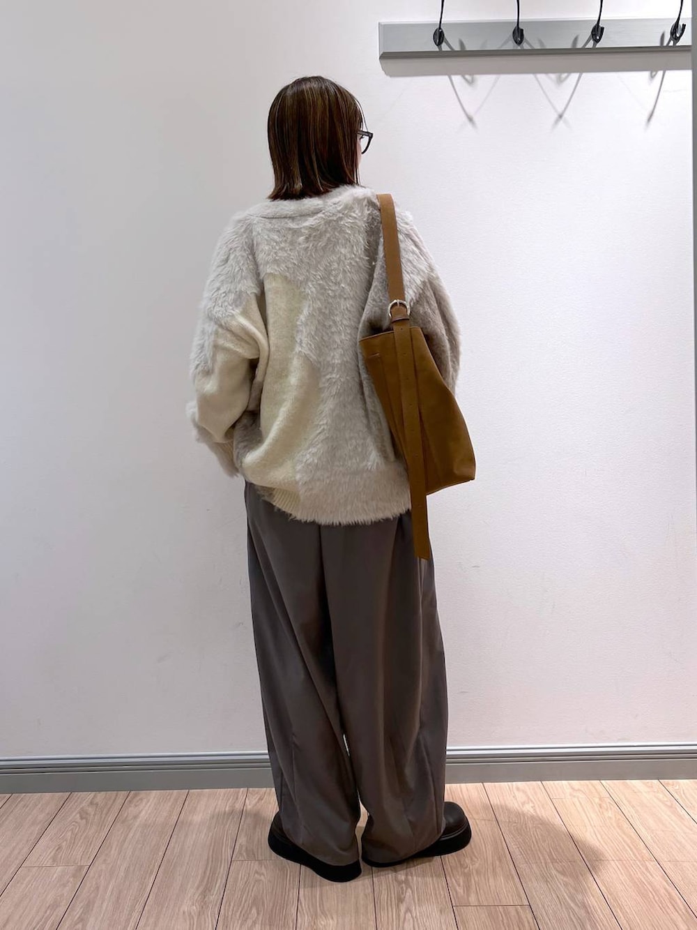 ブラック系のTシャツ/カットソー、ホワイト系のカーディガン/ボレロ、グレー系のその他パンツを着用したレディースの秋コーディネートの6枚目の写真