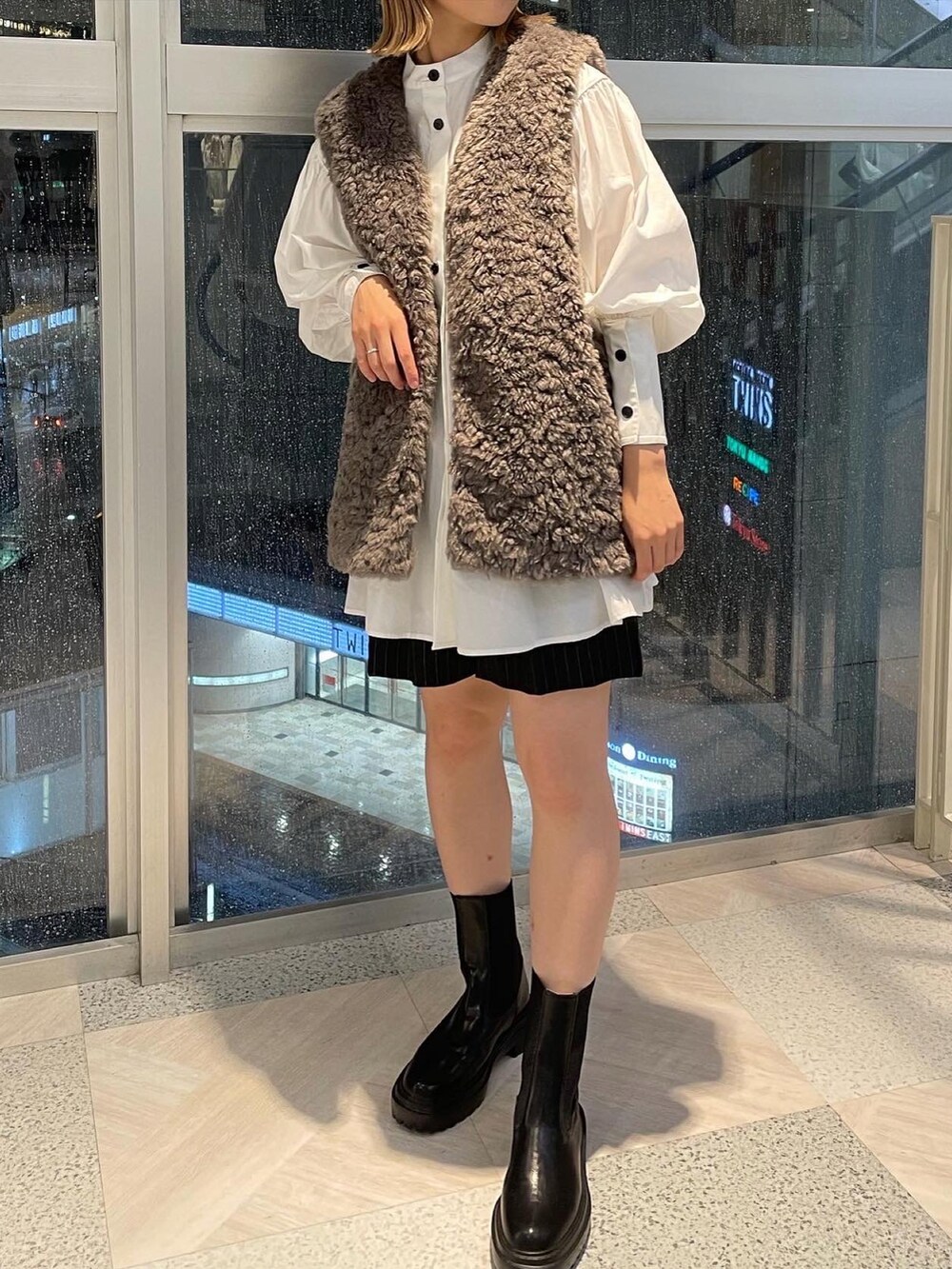 グレー系のベスト、ブラック系のその他パンツを着用したレディースの秋コーディネートの3枚目の写真