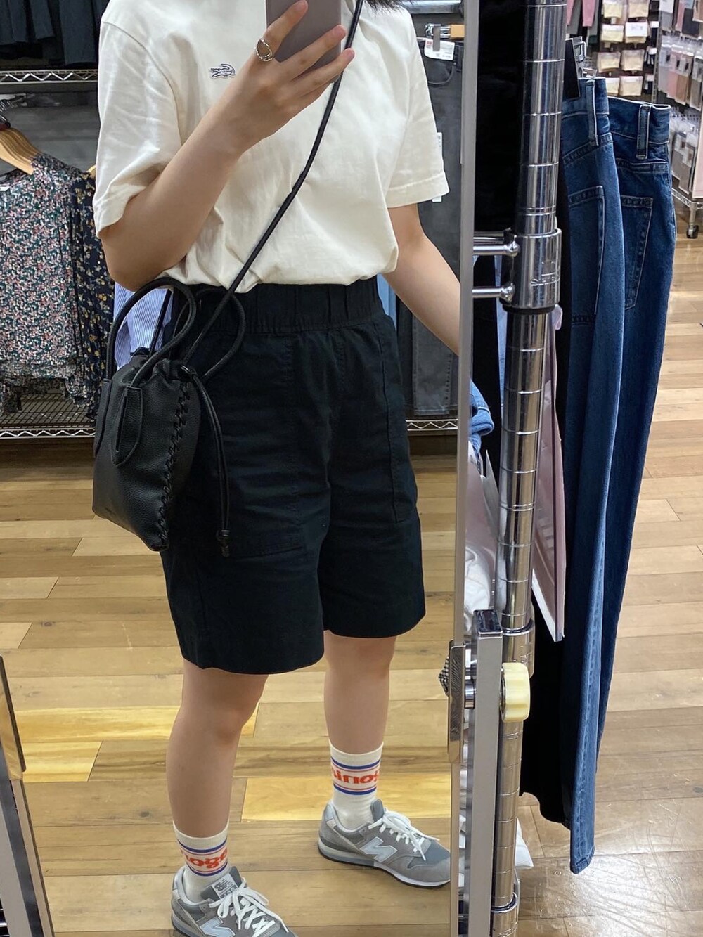 ホワイト系のTシャツ/カットソー、グレー系のスニーカー、ブラック系のショルダーバッグを着用したレディースの夏コーディネートの2枚目の写真