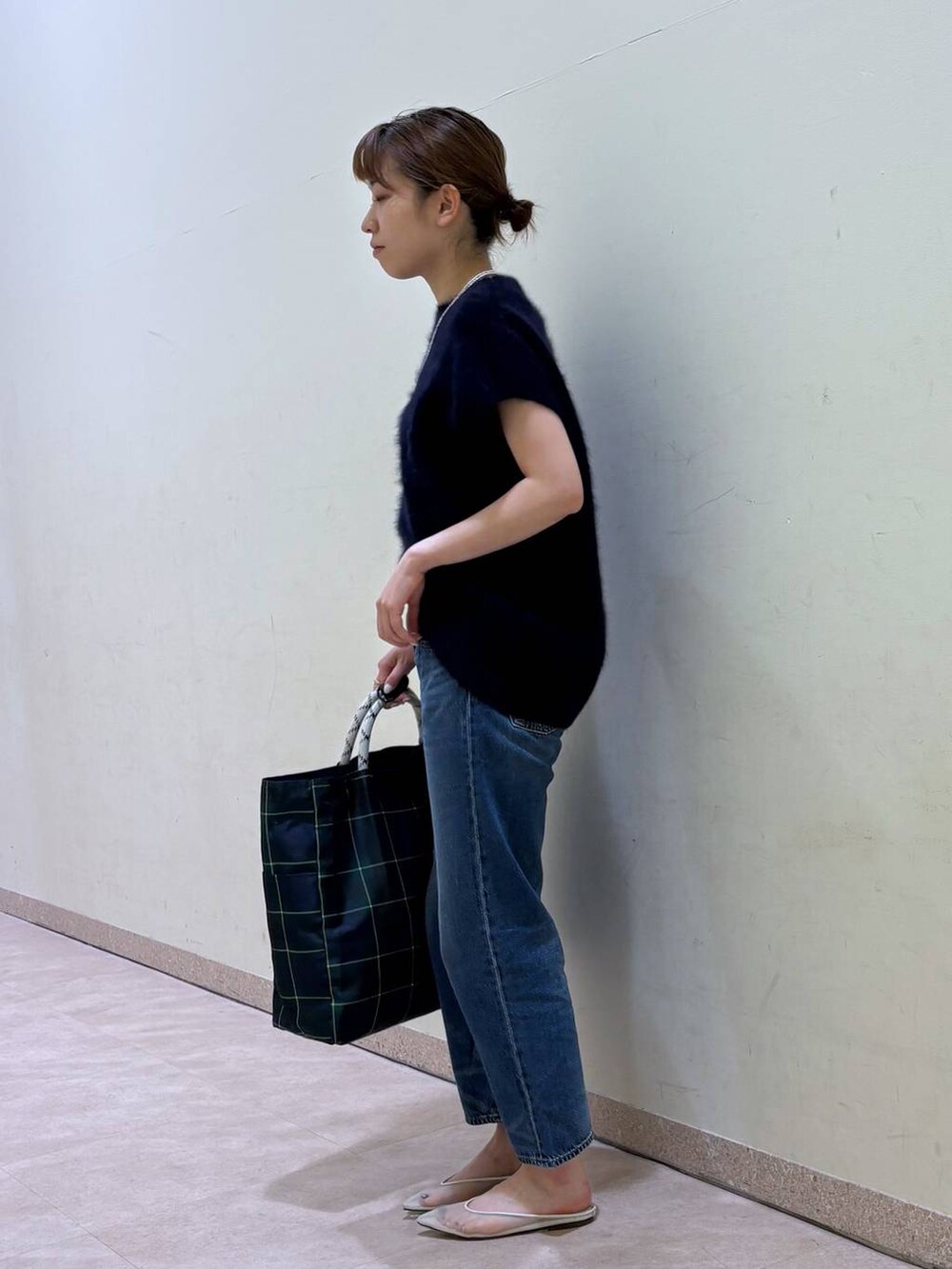 ブルー系のデニムパンツ、ベージュ系のパンプス、ブルー系のニット/セーターを着用したレディースの夏コーディネートの3枚目の写真