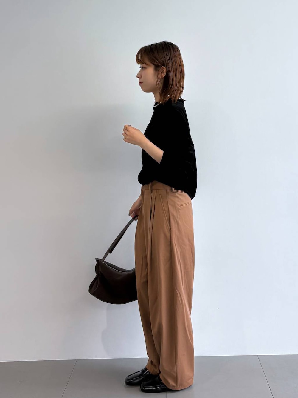 ブラック系のTシャツ/カットソー、ブラウン系のハンドバッグ、シルバー系のチョーカーを着用したレディースの夏コーディネートの2枚目の写真