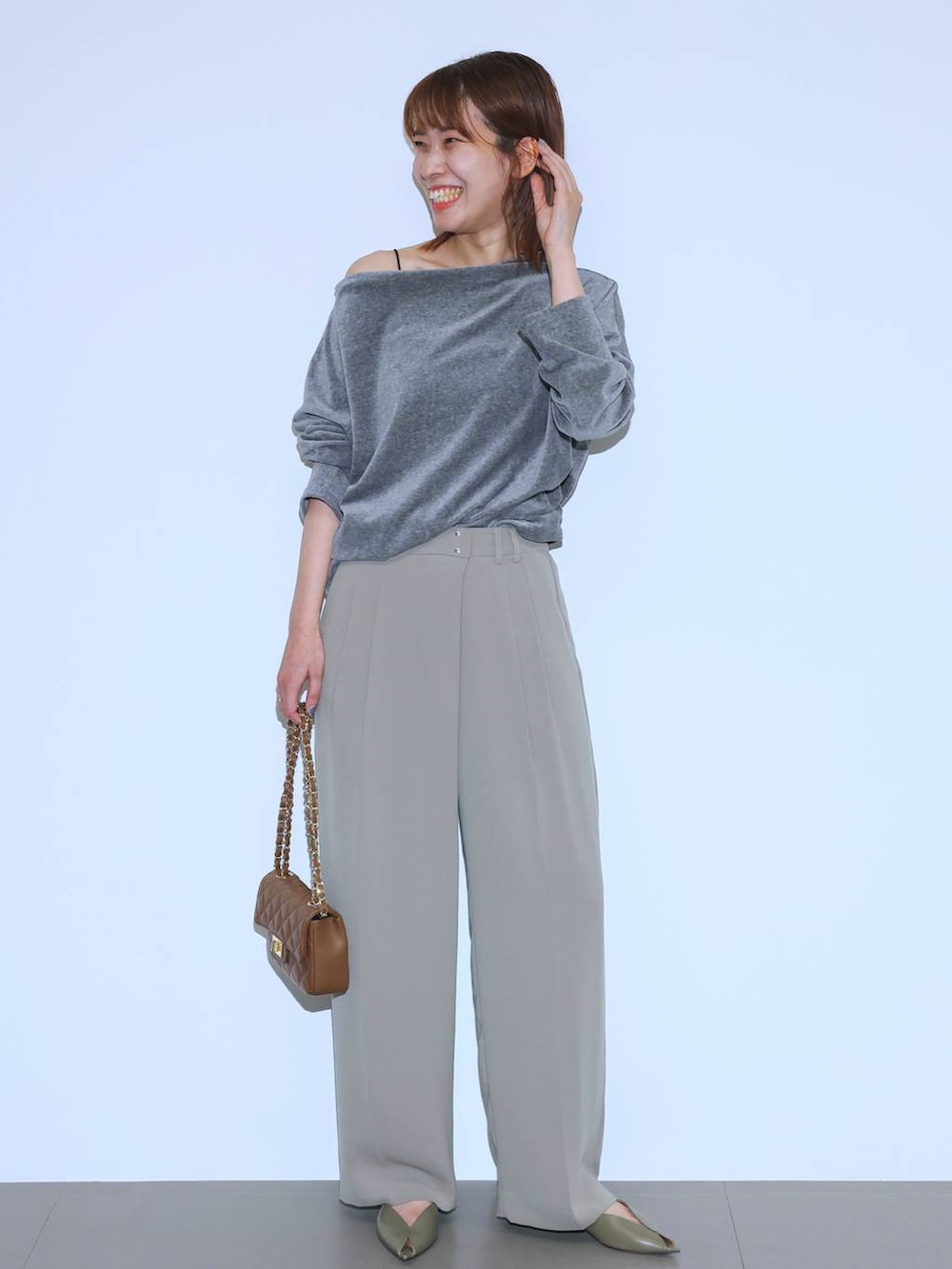 グリーン系のパンプス、ベージュ系のスラックス、グレー系のTシャツ/カットソーを着用したレディースの夏コーディネートの4枚目の写真
