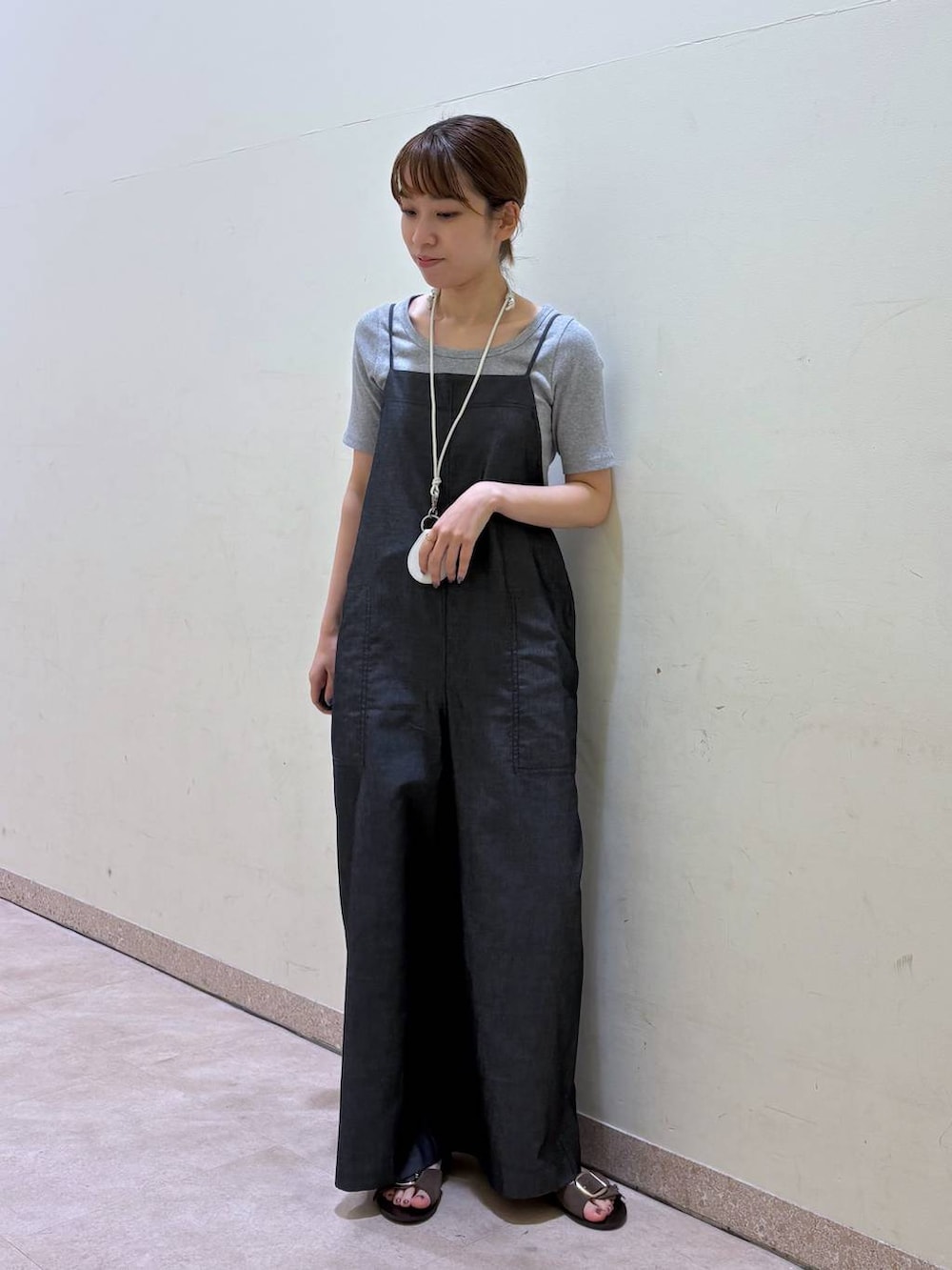 グレー系のTシャツ/カットソー、ブルー系のサロペット/オーバーオール、ブラウン系のサンダルを着用したレディースの夏コーディネートの4枚目の写真