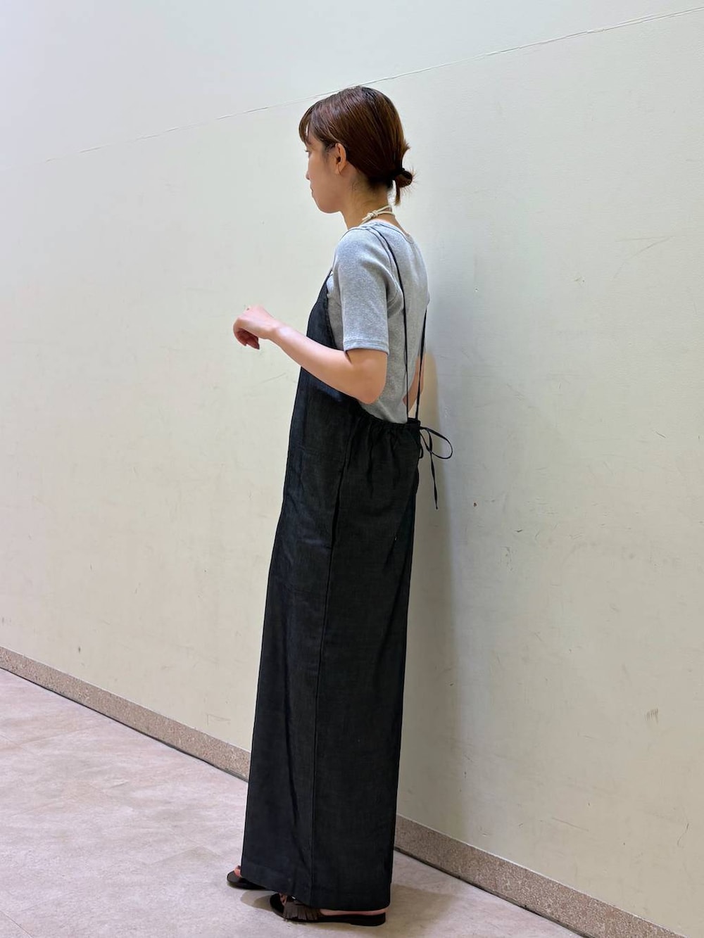 グレー系のTシャツ/カットソー、ブルー系のサロペット/オーバーオール、ブラウン系のサンダルを着用したレディースの夏コーディネートの2枚目の写真
