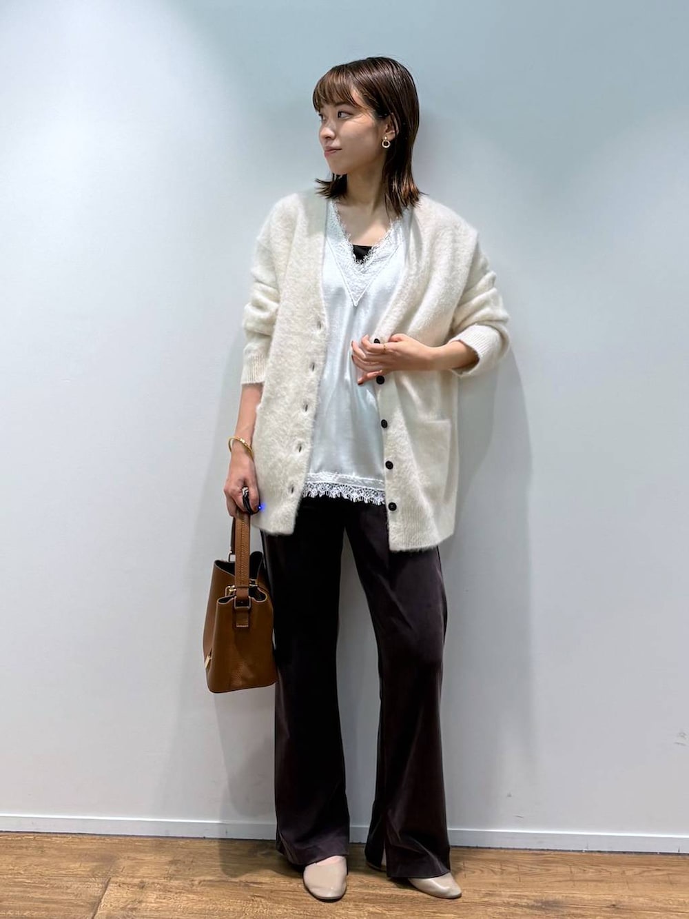 ホワイト系のシャツ/ブラウス、ベージュ系のカーディガン/ボレロ、ブラウン系のショルダーバッグを着用したレディースの秋コーディネートの4枚目の写真