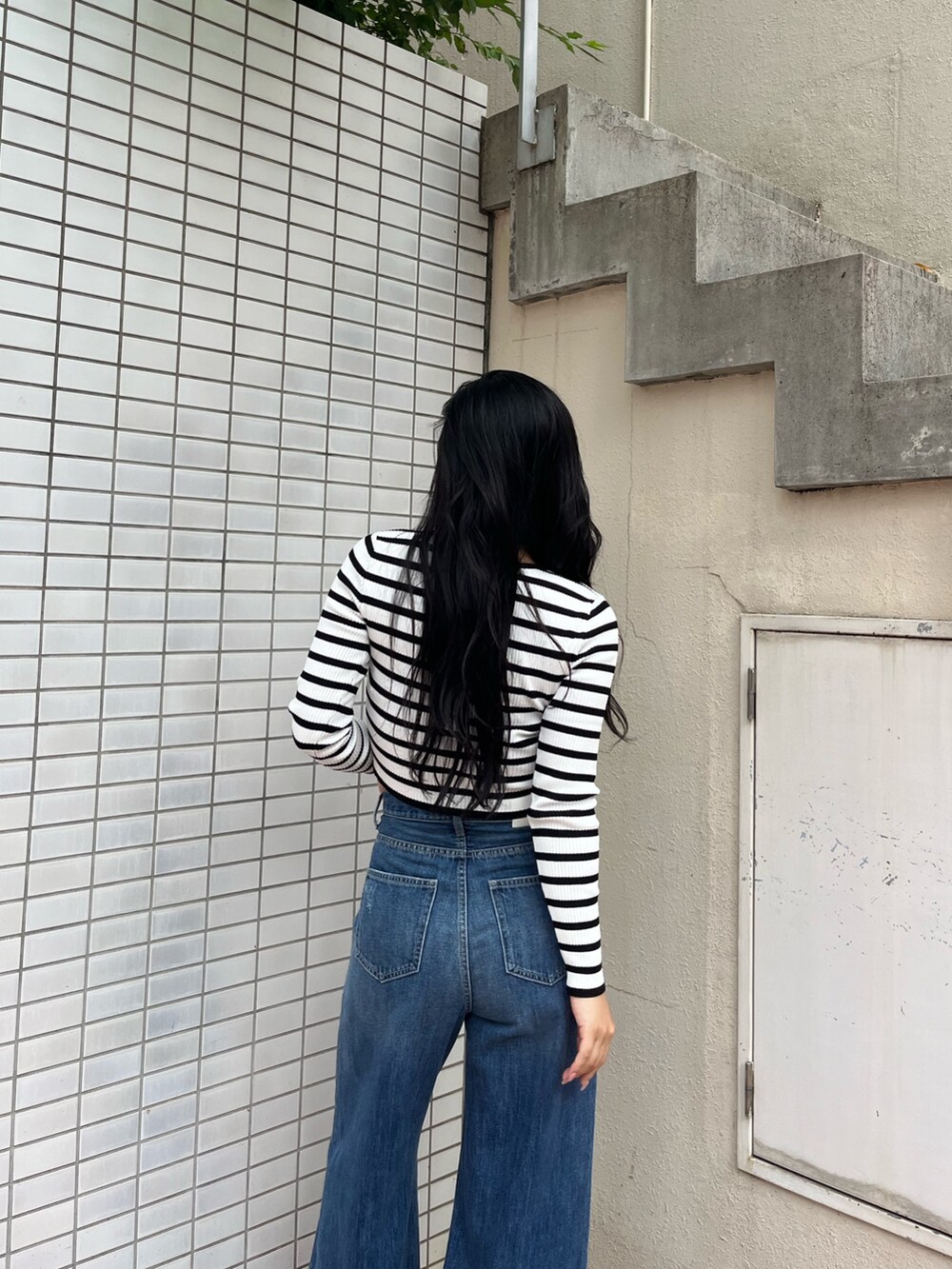 ブルー系のデニムパンツ、その他のニット/セーター、ベージュ系のブーツを着用したレディースの秋コーディネートの5枚目の写真