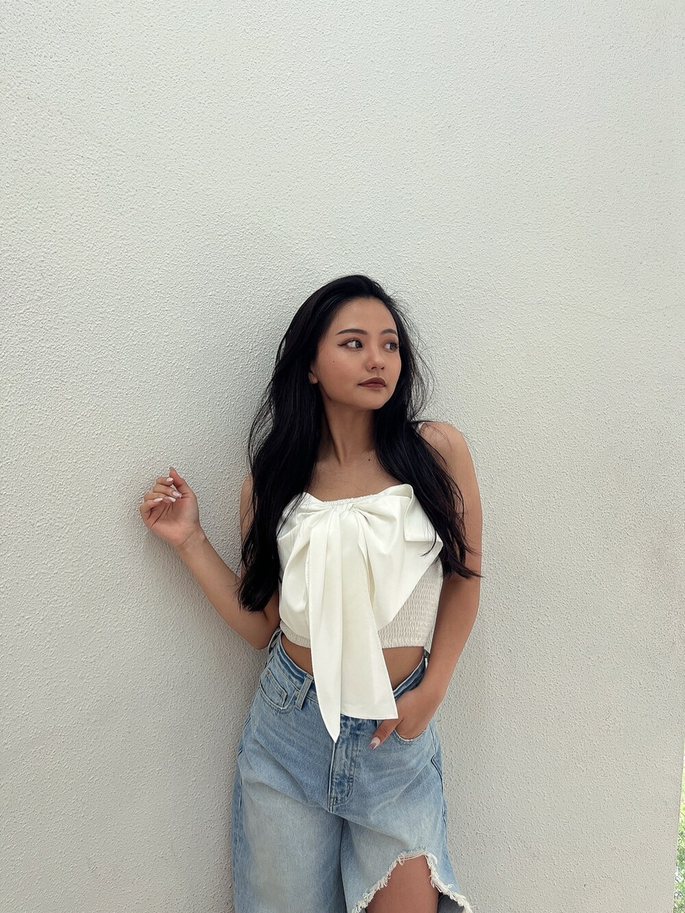 ブルー系のデニムパンツ、ホワイト系のパンプス、ホワイト系のシャツ/ブラウスを着用したレディースの夏コーディネートの3枚目の写真