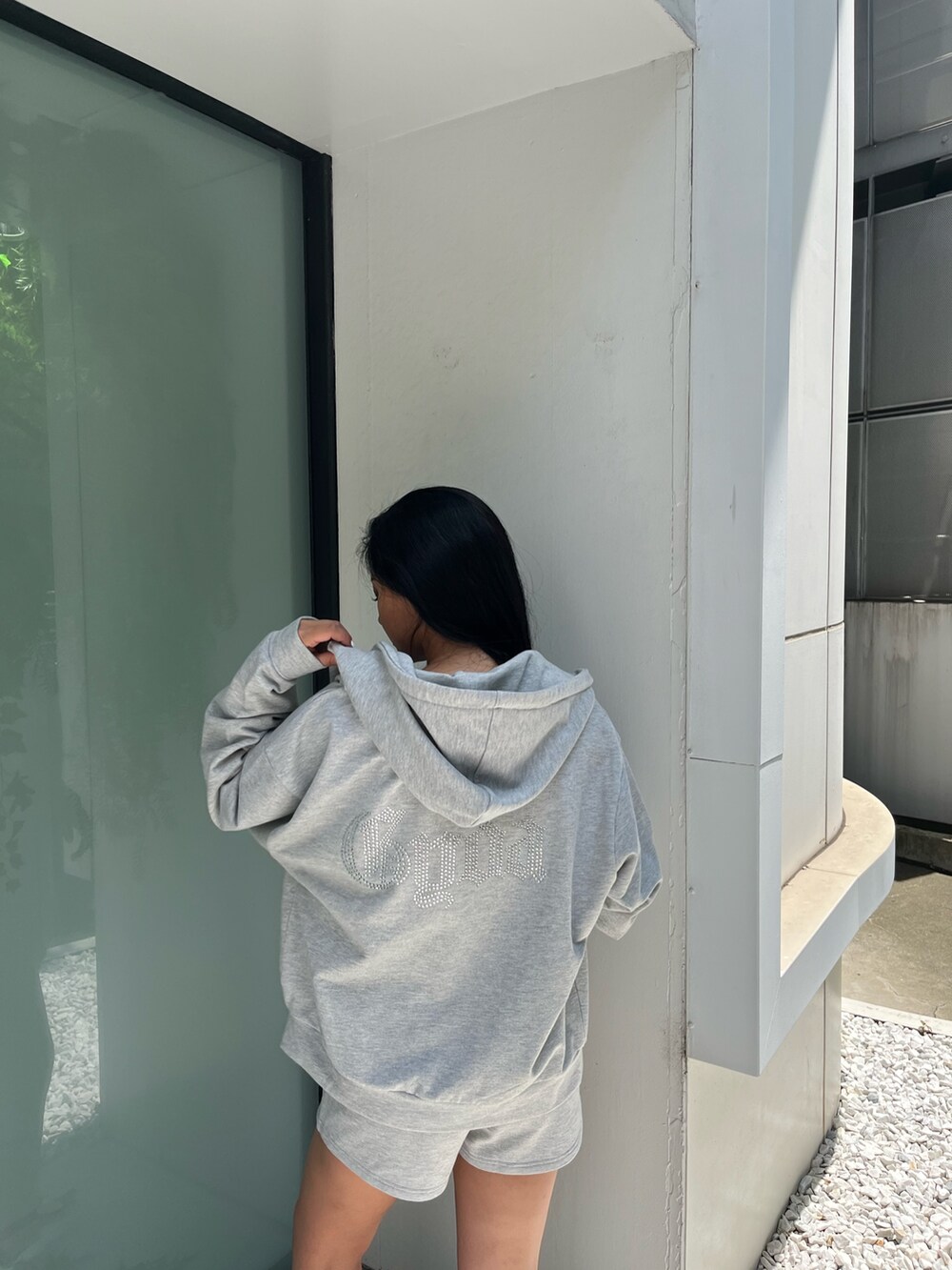 グレー系のパーカー、ホワイト系のキャミソール、グレー系のその他パンツを着用したレディースの夏コーディネートの4枚目の写真