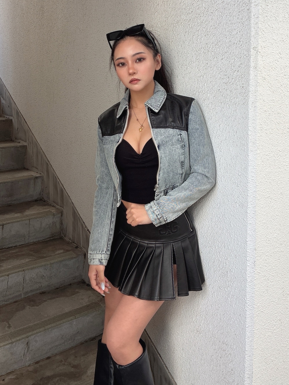 ブルー系のデニムジャケット、ブラック系のキャミソール、ブラック系のスカートを着用したレディースの冬コーディネートの3枚目の写真