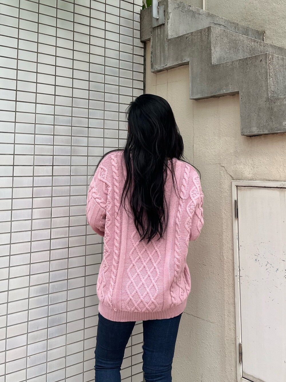 ピンク系のニット/セーター、ブルー系のデニムパンツ、ブラウン系のブーツを着用したレディースの秋コーディネートの4枚目の写真