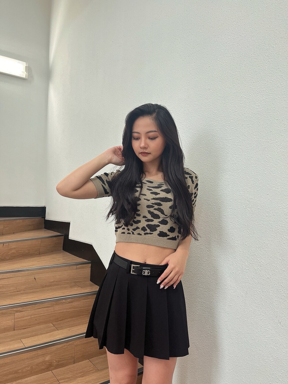 ベージュ系のニット/セーター、ブラック系のスカート、ブラック系のブーツを着用したレディースの夏コーディネートの3枚目の写真