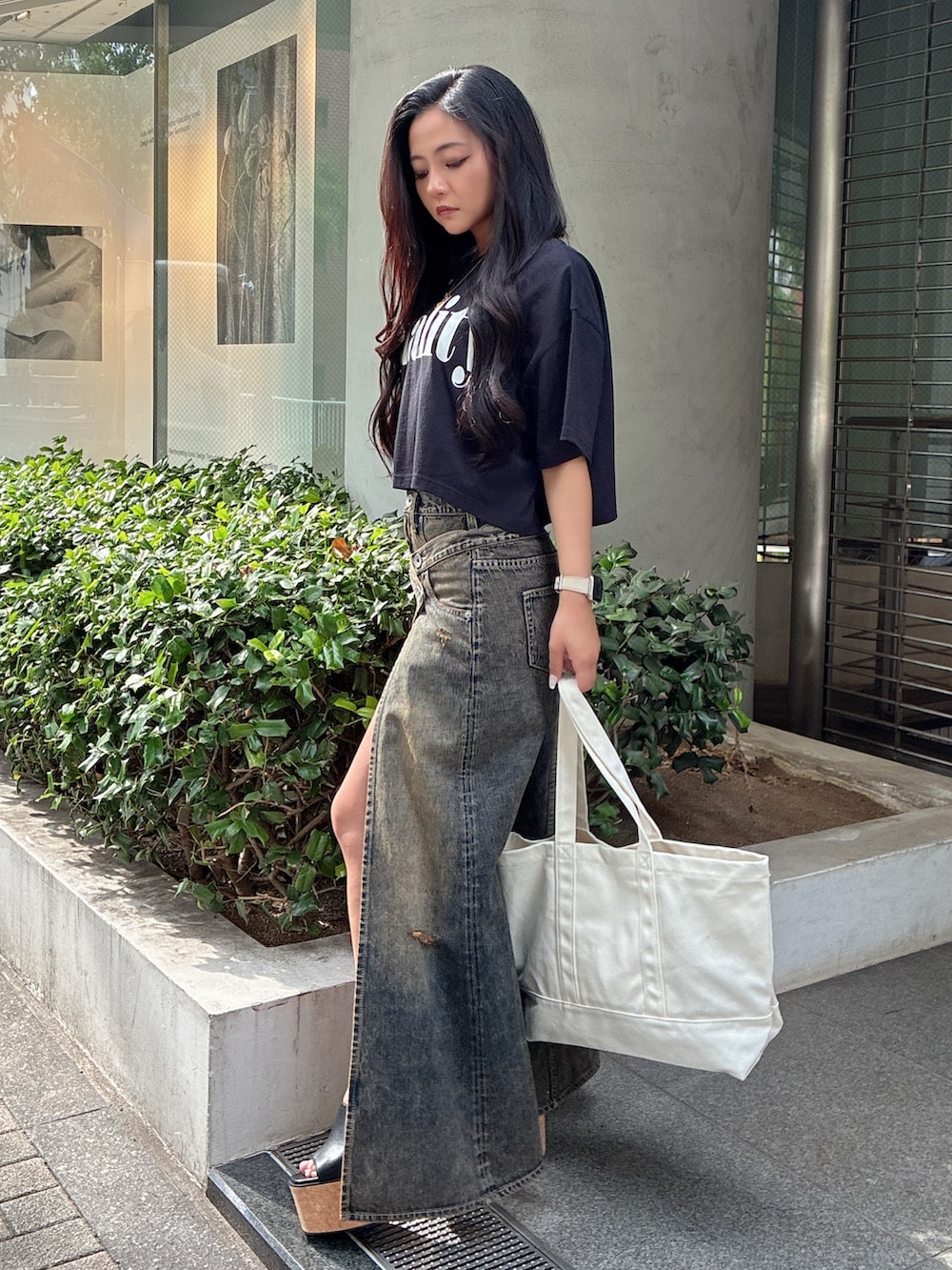 ブラック系のTシャツ/カットソー、ブルー系のデニムスカート、ブラック系のサンダルを着用したレディースの夏コーディネートの2枚目の写真