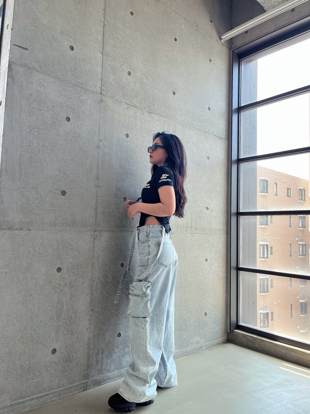 ブラック系のTシャツ/カットソー、ブルー系のデニムパンツ、ブラック系のスニーカーを着用したレディースの夏コーディネートの2枚目の写真