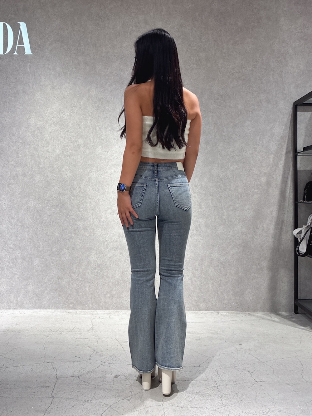 ホワイト系のチューブトップ、ブルー系のデニムパンツ、ホワイト系のブーツを着用したレディースの秋コーディネートの3枚目の写真