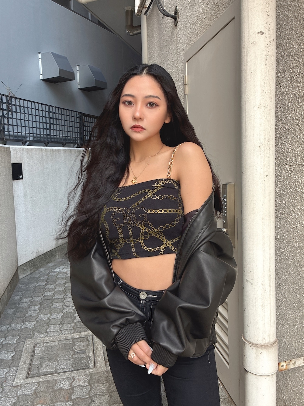 ブラック系のブルゾン、その他のチューブトップ、ブラック系のデニムパンツを着用したレディースの冬コーディネートの3枚目の写真