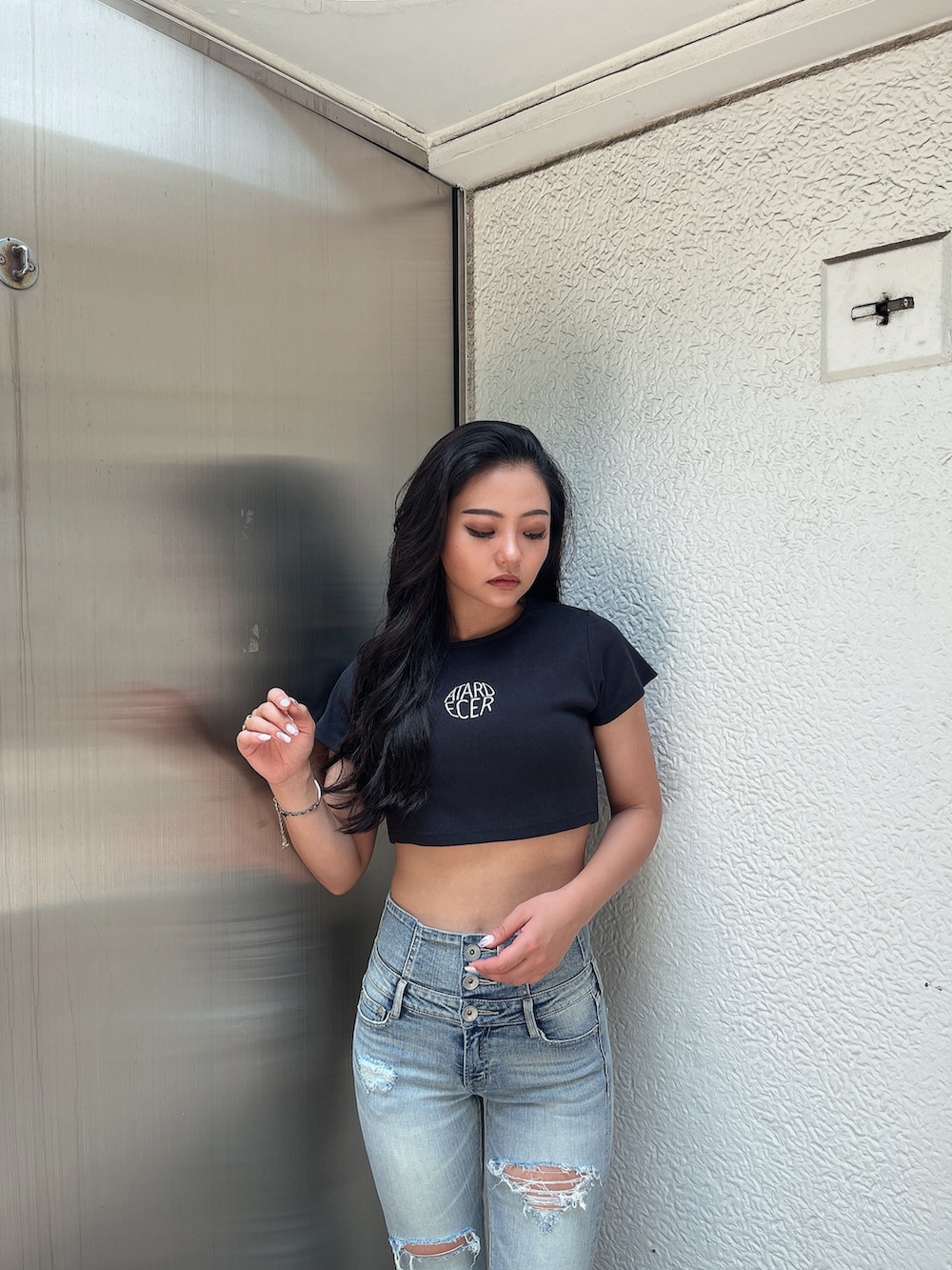 ブラック系のTシャツ/カットソー、ブルー系のデニムパンツ、ホワイト系のサンダルを着用したレディースの夏コーディネートの4枚目の写真