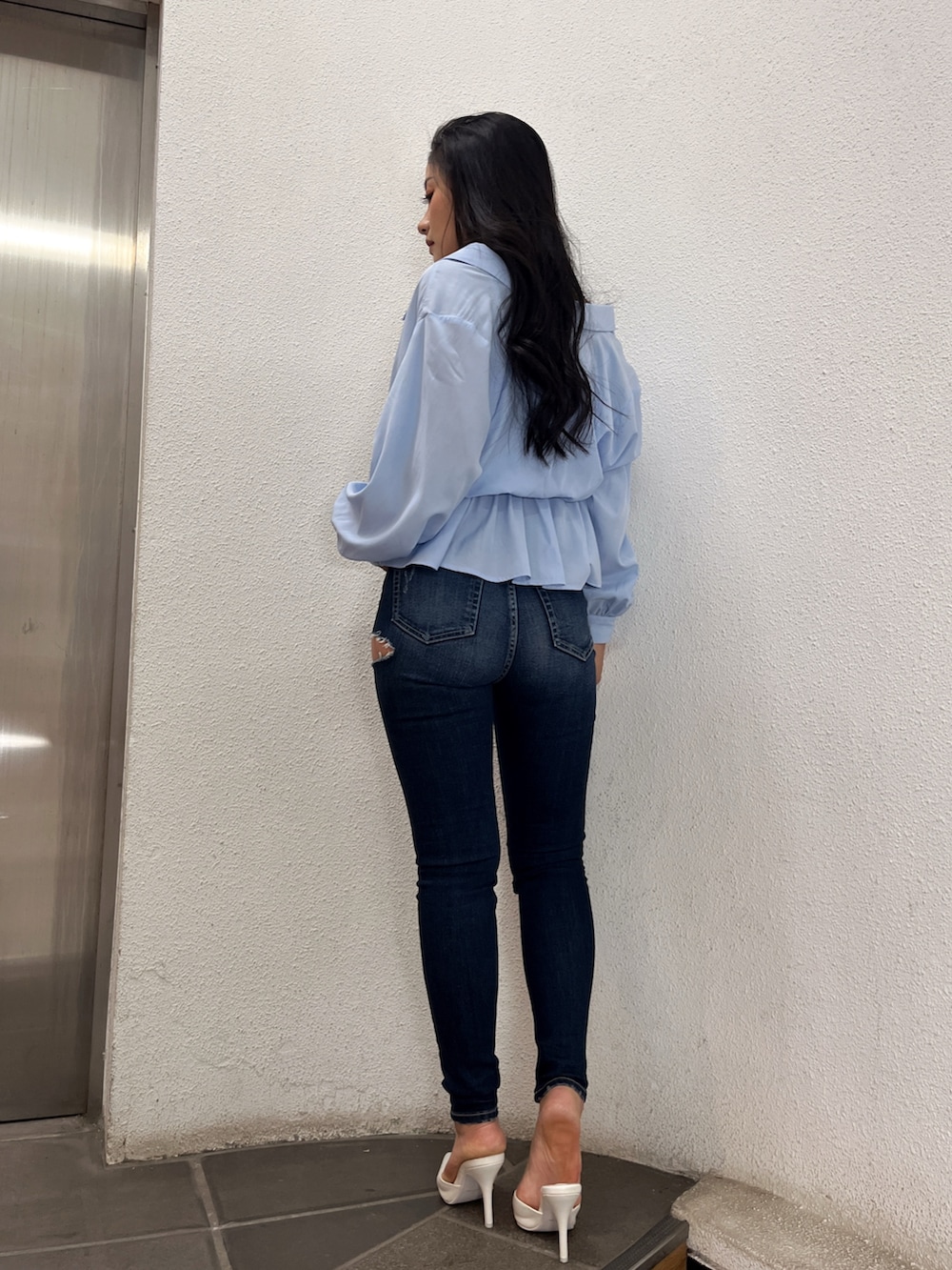 ブルー系のシャツ/ブラウス、ブルー系のデニムパンツ、ホワイト系のパンプスを着用したレディースの冬コーディネートの2枚目の写真