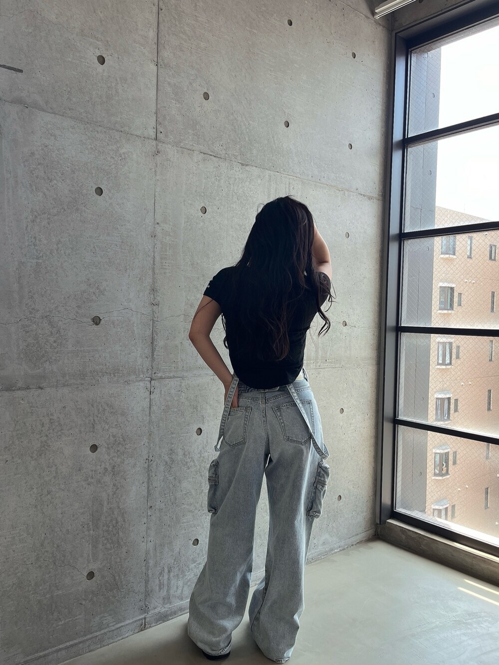 ブラック系のTシャツ/カットソー、ブルー系のデニムパンツ、ブラック系のスニーカーを着用したレディースの夏コーディネートの3枚目の写真