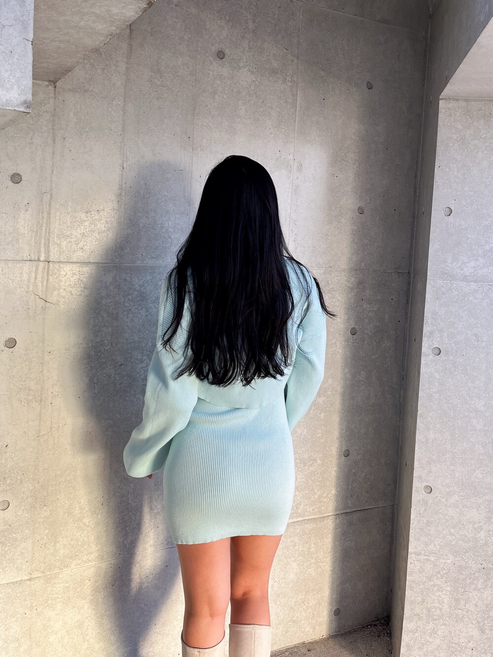 ブルー系のワンピース、ホワイト系のブーツを着用したレディースの冬コーディネートの4枚目の写真