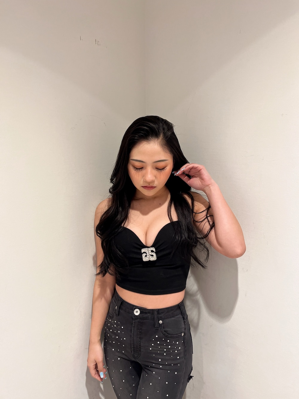 ブラック系のデニムパンツ、ブラック系のキャミソール、ブラック系のパンプスを着用したレディースの冬コーディネートの3枚目の写真