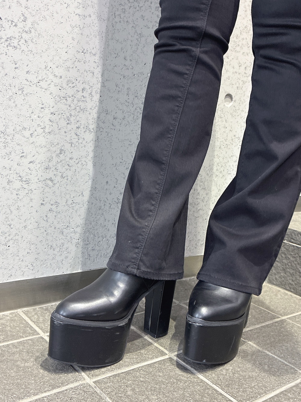 ホワイト系のチューブトップ、ブラック系のデニムパンツ、ブラック系のブーツを着用したレディースの夏コーディネートの6枚目の写真