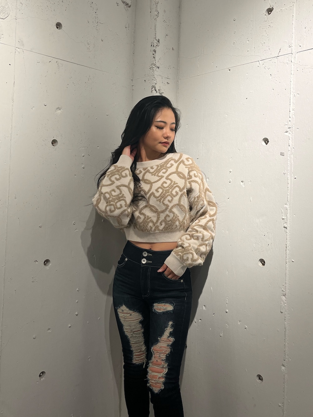 ホワイト系のニット/セーター、ブラウン系のブーツ、ブルー系のデニムパンツを着用したレディースの秋コーディネートの2枚目の写真