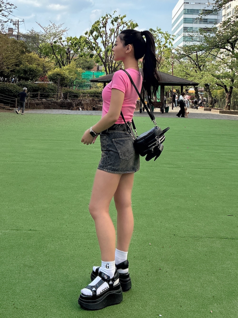 ピンク系のTシャツ/カットソー、ブルー系のデニムスカート、ブラック系のバックパック/リュックを着用したレディースの春コーディネートの2枚目の写真
