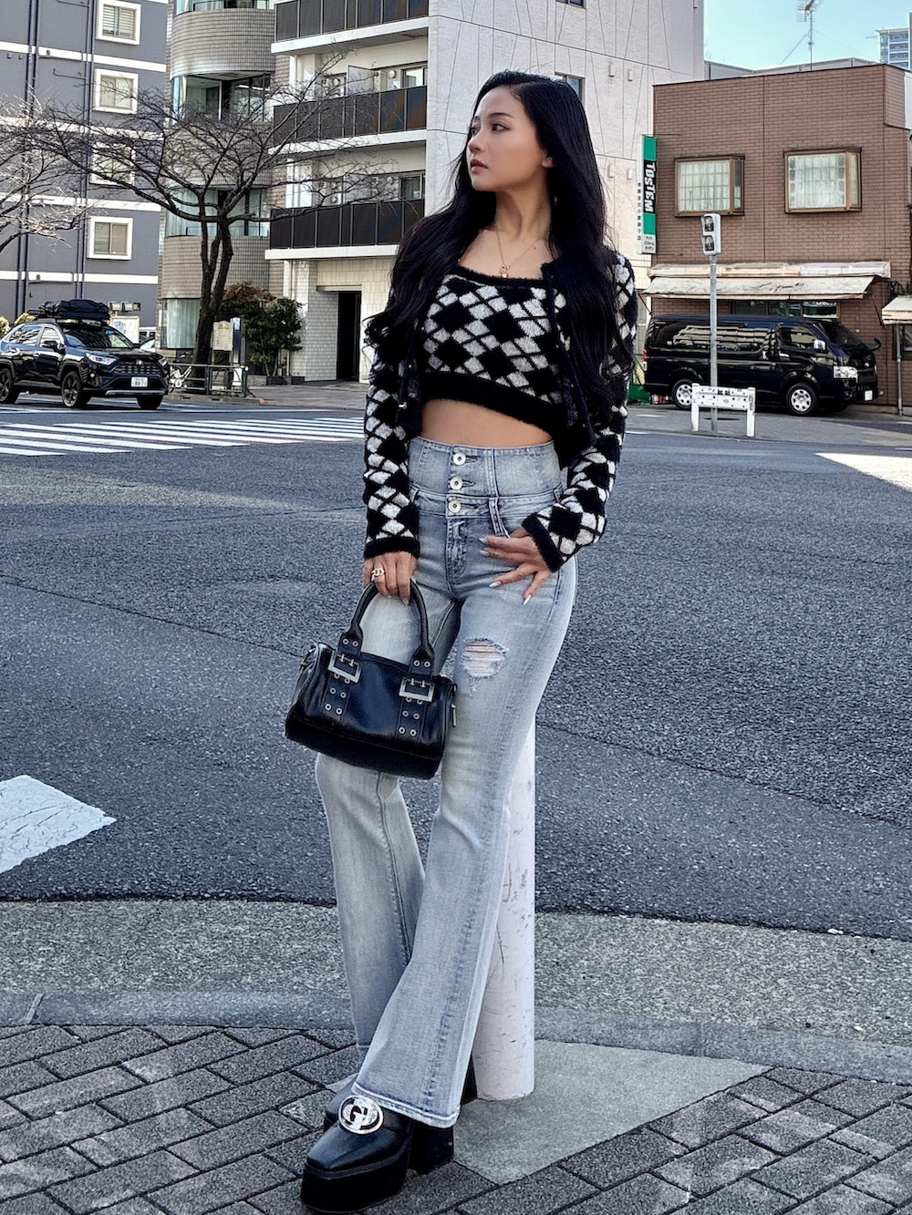 ブラック系のカーディガン/ボレロ、ブラック系のキャミソール、ブラック系のブーツを着用したレディースの冬コーディネートの2枚目の写真