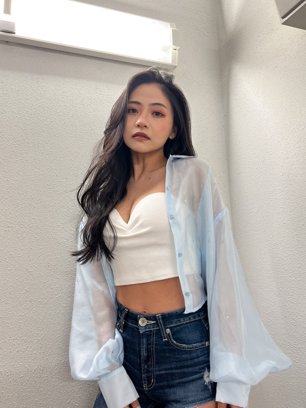 ホワイト系のチューブトップ、ブルー系のシャツ/ブラウス、ブルー系のデニムパンツを着用したレディースの春コーディネートの2枚目の写真