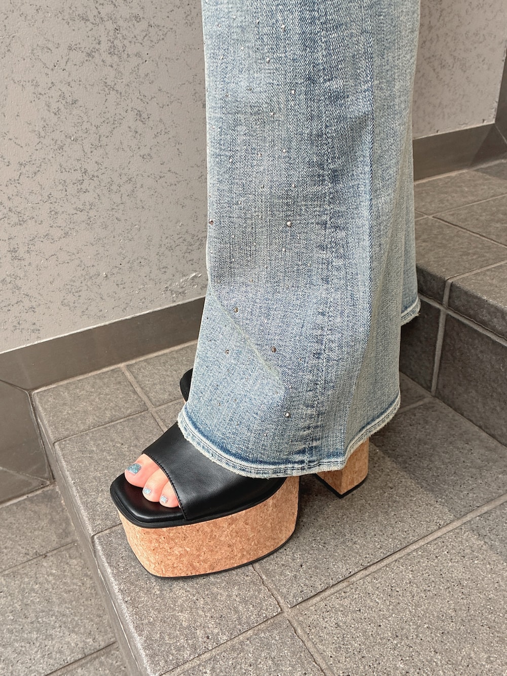 ブラック系のキャミソール、ブルー系のデニムパンツ、ブラック系のサンダルを着用したレディースの夏コーディネートの7枚目の写真