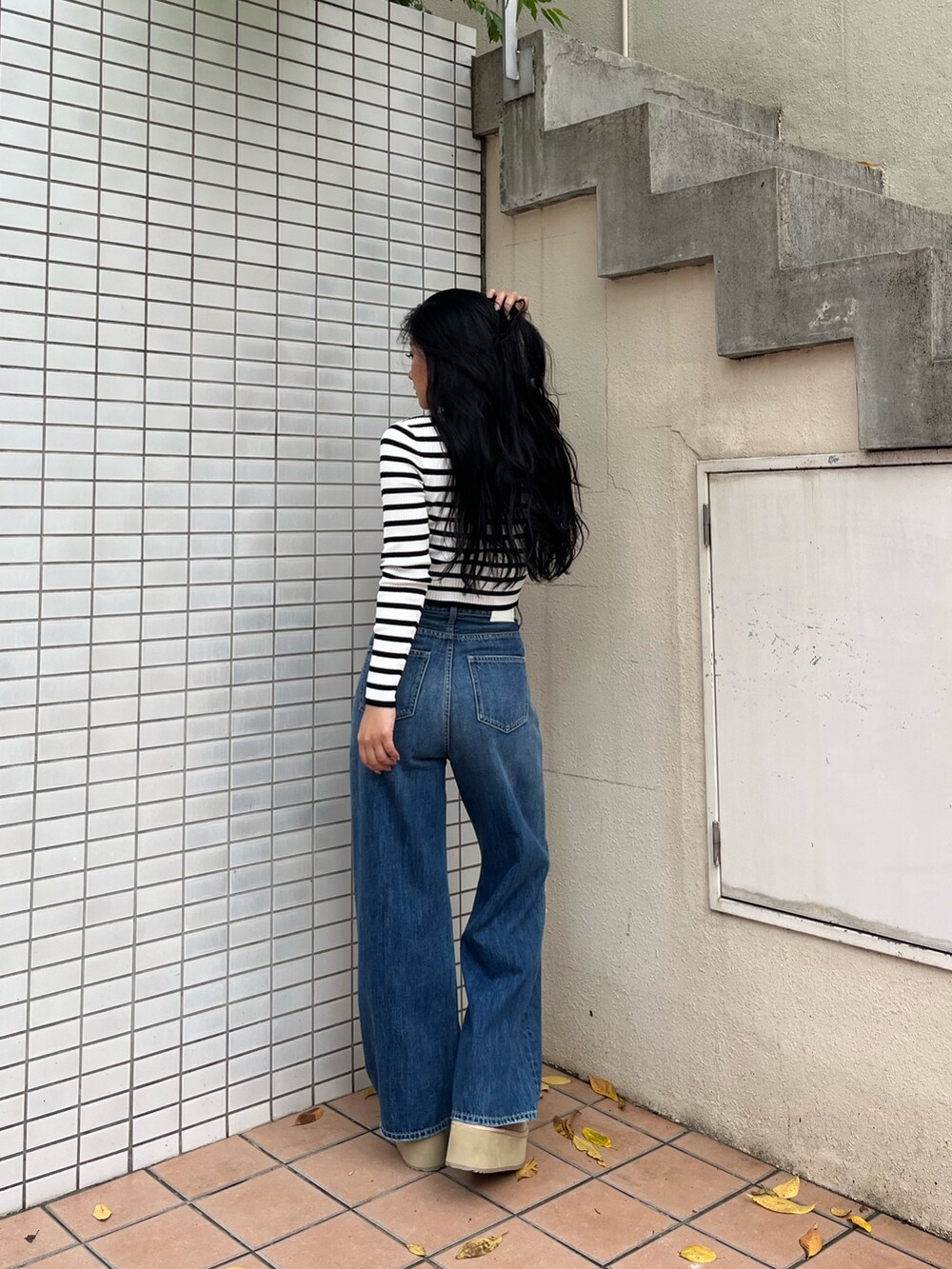 ブルー系のデニムパンツ、その他のニット/セーター、ベージュ系のブーツを着用したレディースの秋コーディネートの3枚目の写真