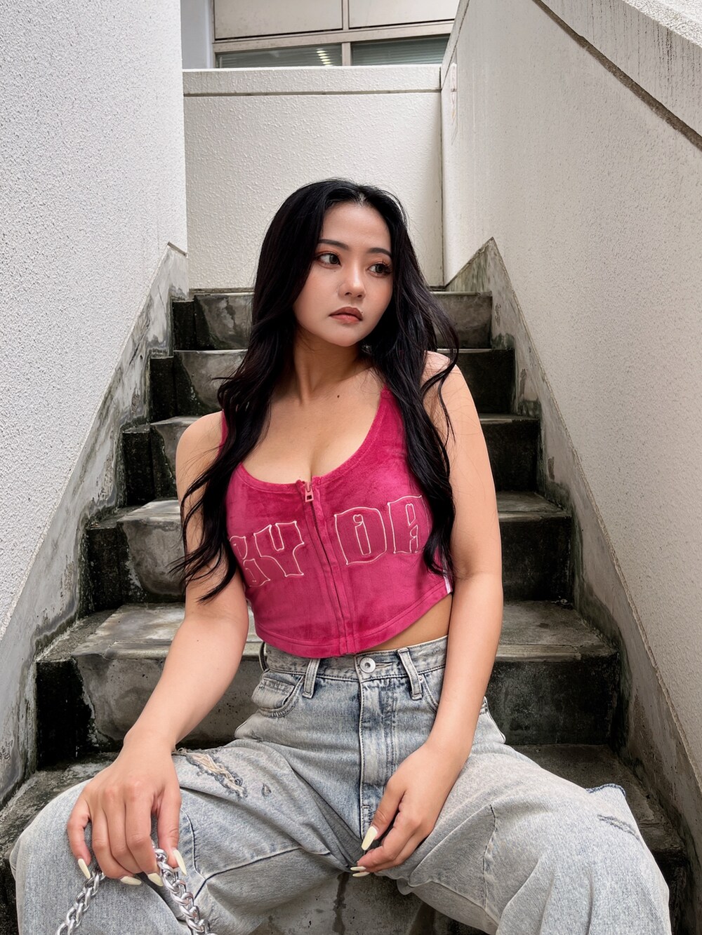 ブルー系のデニムパンツ、ピンク系のキャミソール、ホワイト系のハンドバッグを着用したレディースの夏コーディネートの2枚目の写真