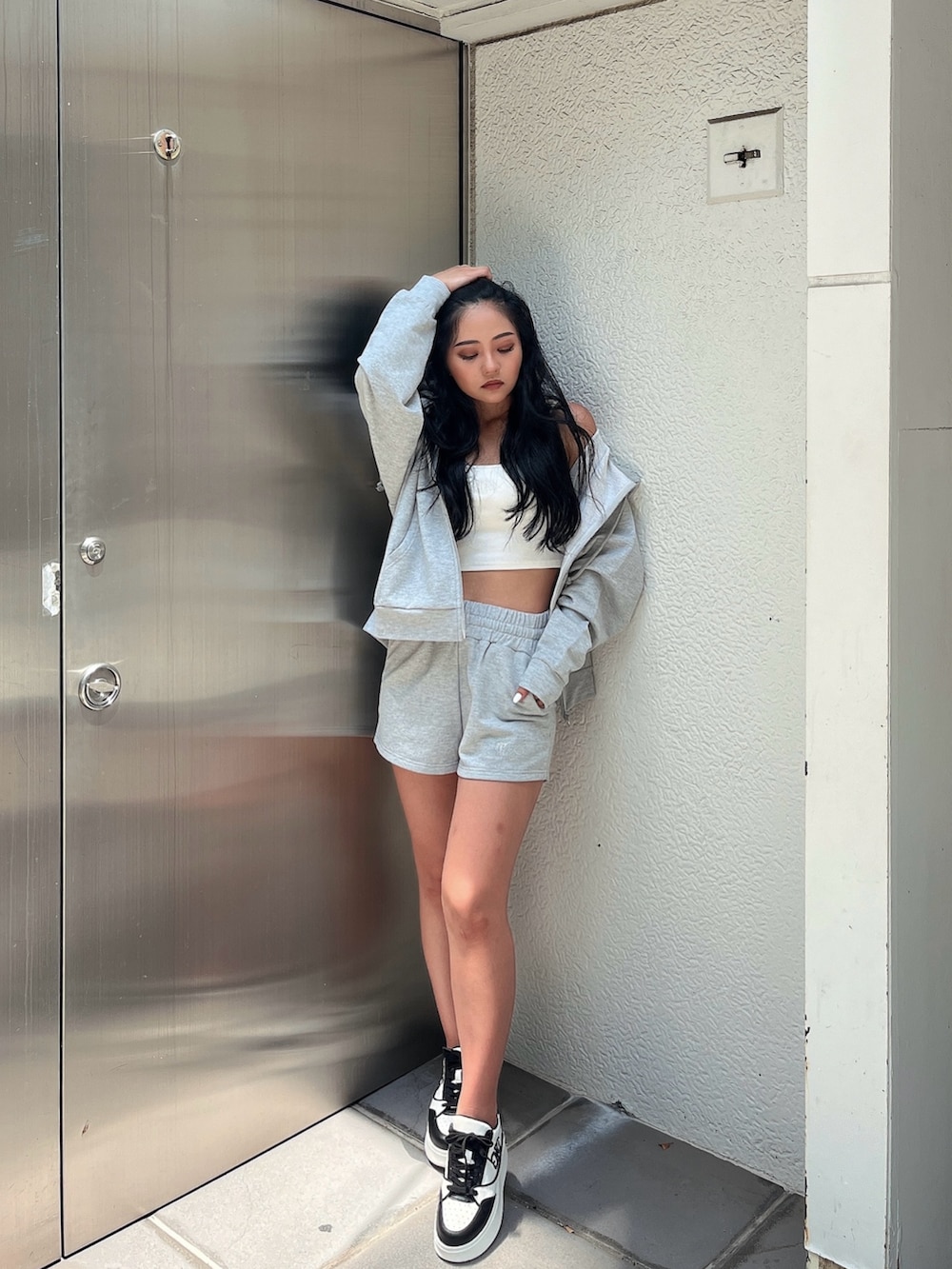 グレー系のパーカー、ホワイト系のキャミソール、グレー系のその他パンツを着用したレディースの夏コーディネートの2枚目の写真