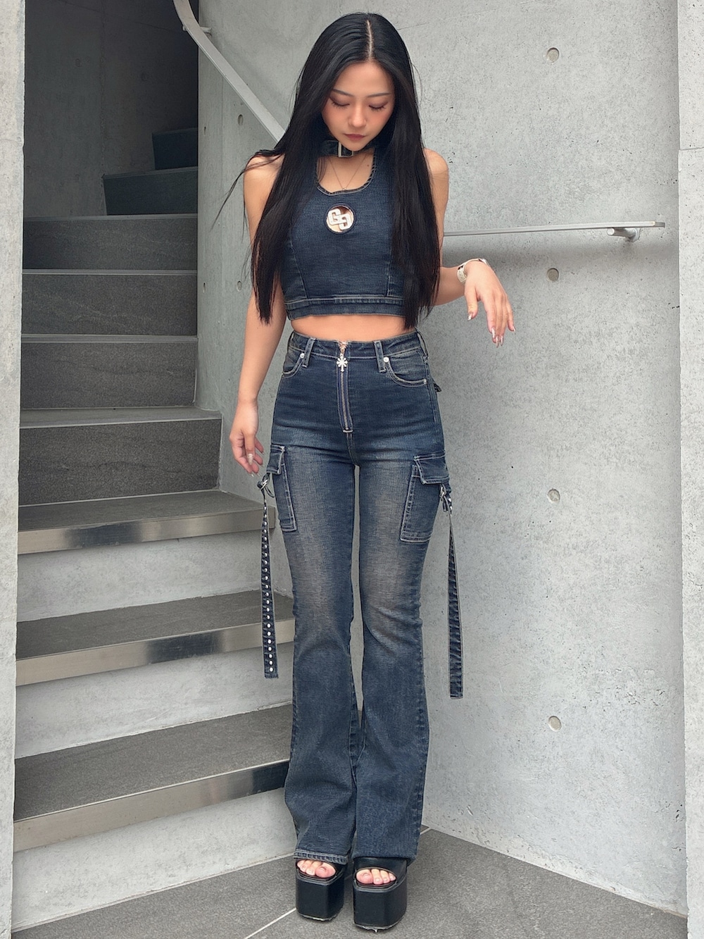 ブルー系のタンクトップ、ブルー系のデニムパンツ、ブラック系のサンダルを着用したレディースの春コーディネートの2枚目の写真