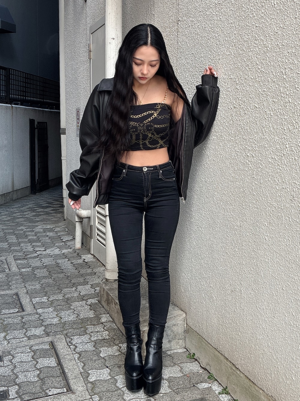 ブラック系のブルゾン、その他のチューブトップ、ブラック系のデニムパンツを着用したレディースの冬コーディネートの2枚目の写真