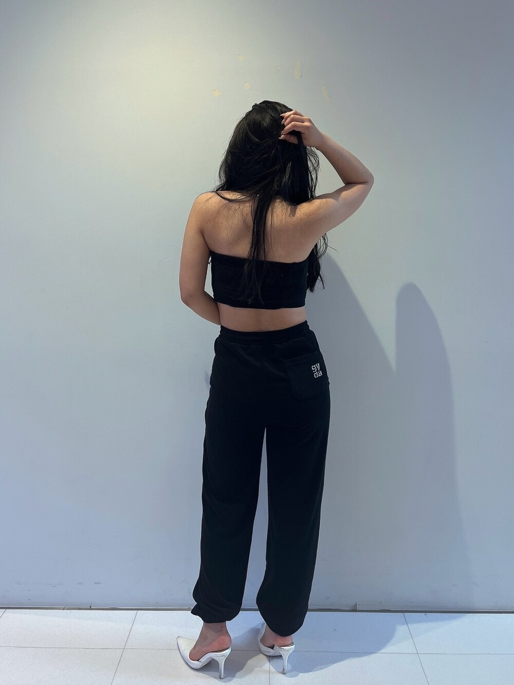 ブラック系のチューブトップ、ブラック系のその他パンツ、ホワイト系のパンプスを着用したレディースの春コーディネートの3枚目の写真