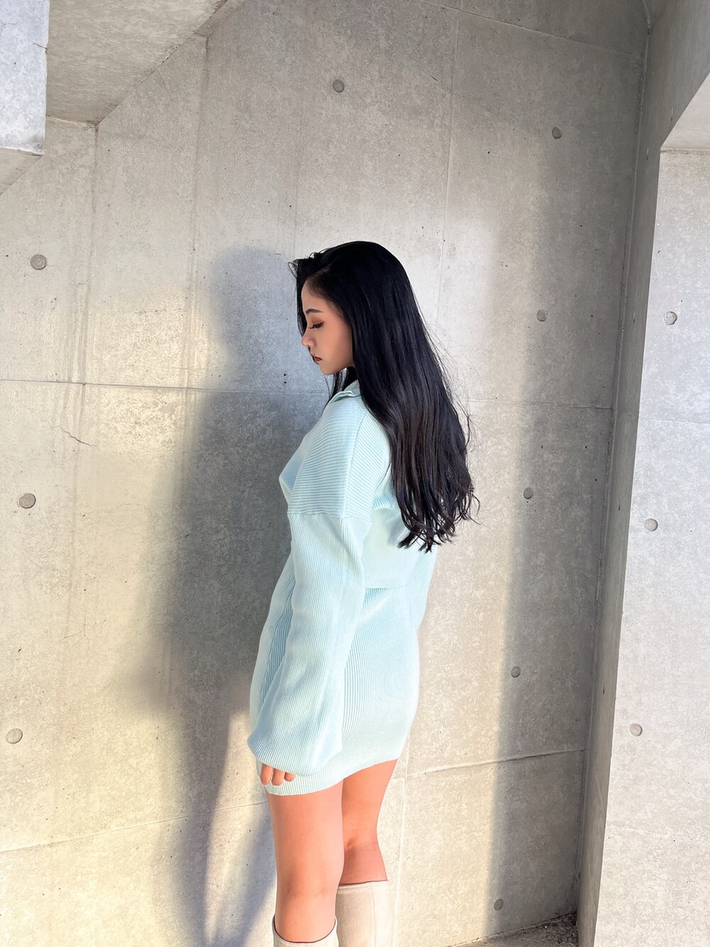 ブルー系のワンピース、ホワイト系のブーツを着用したレディースの冬コーディネートの3枚目の写真