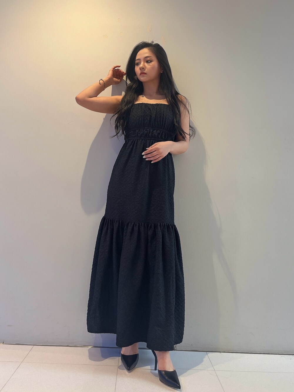 ブラック系のワンピース、ブラック系のパンプスを着用したレディースの春コーディネートの2枚目の写真