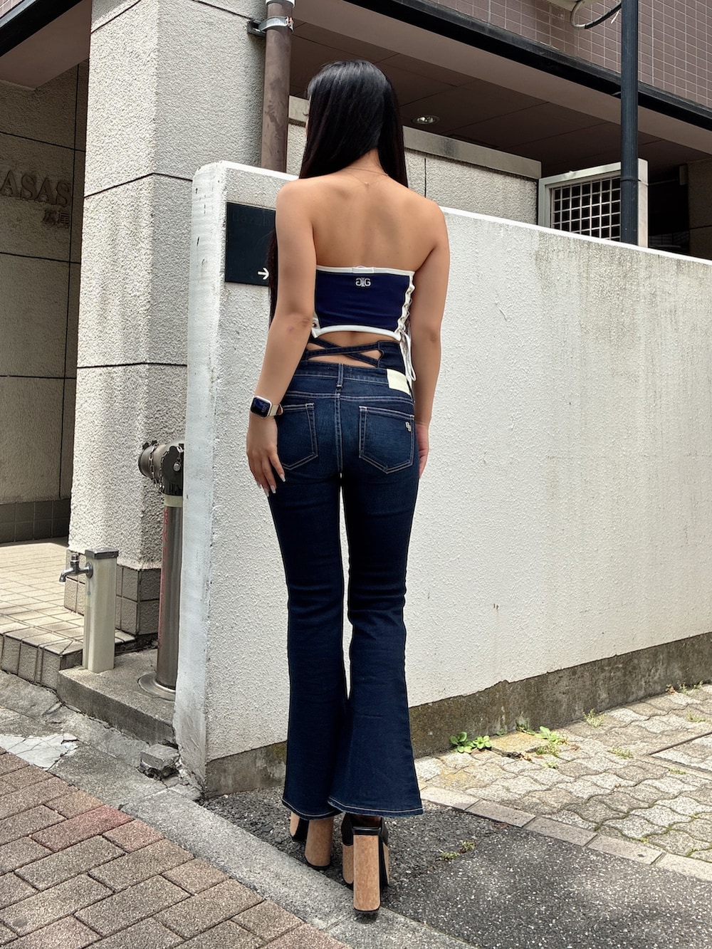 ブルー系のチューブトップ、ブルー系のデニムパンツ、ブラック系のサンダルを着用したレディースの夏コーディネートの3枚目の写真