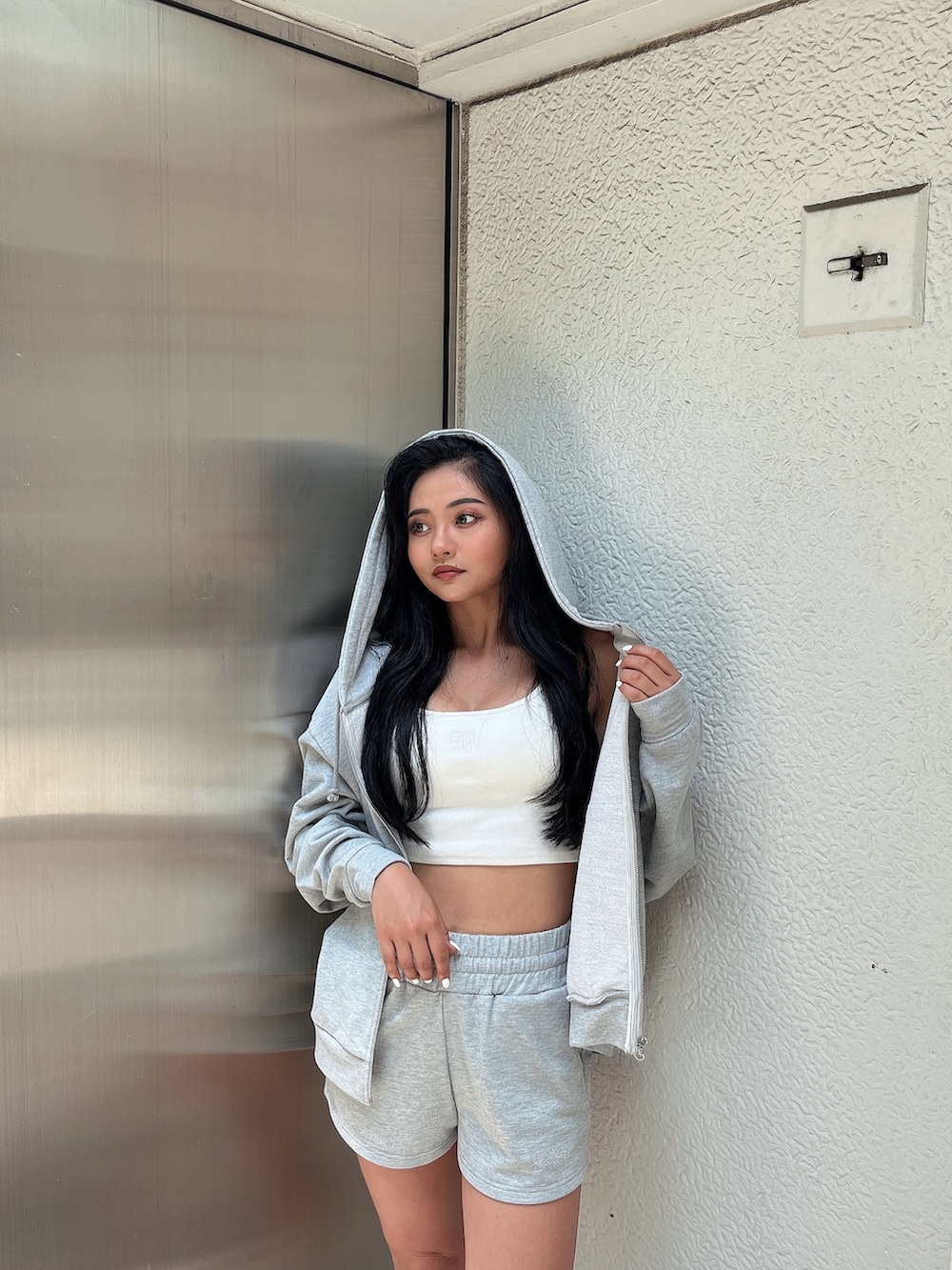 グレー系のパーカー、ホワイト系のキャミソール、グレー系のその他パンツを着用したレディースの夏コーディネートの3枚目の写真