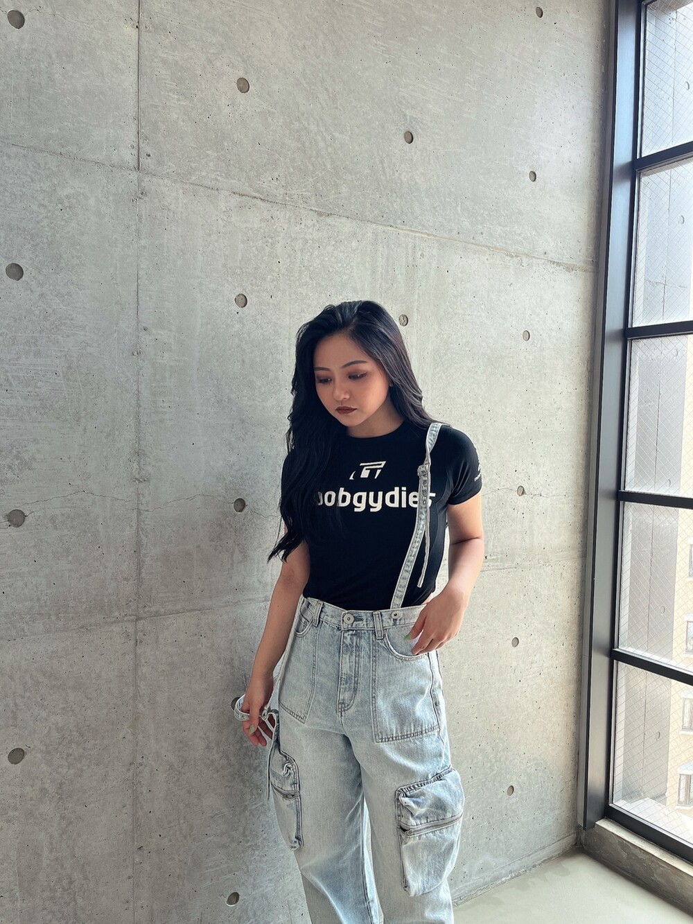 ブラック系のTシャツ/カットソー、ブルー系のデニムパンツ、ブラック系のスニーカーを着用したレディースの夏コーディネートの4枚目の写真