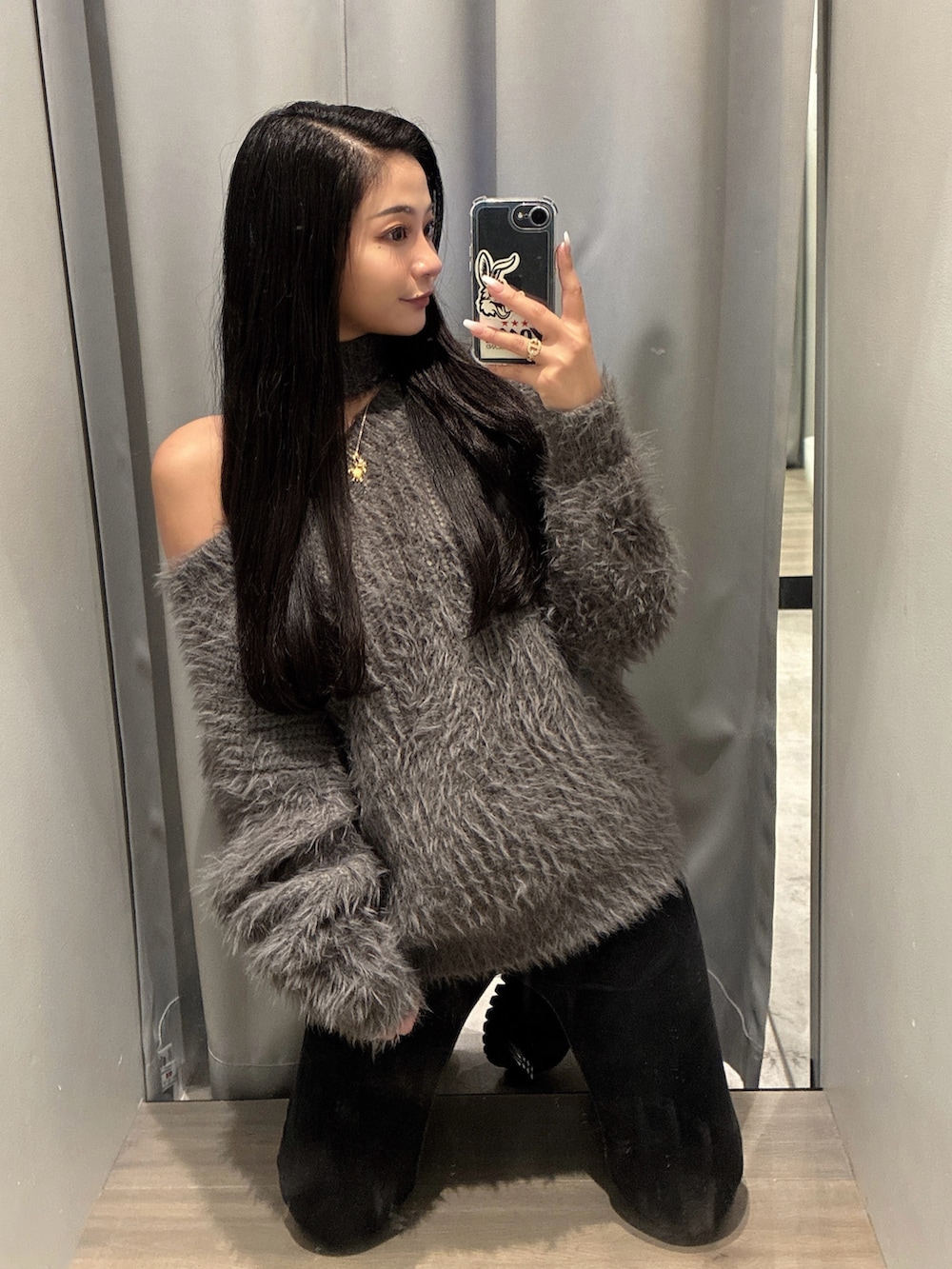 グレー系のニット/セーター、ブラック系のデニムパンツを着用したレディースの秋コーディネートの2枚目の写真