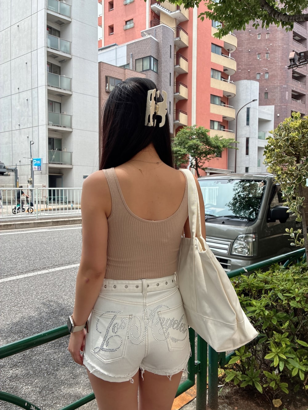 ベージュ系のキャミソール、ホワイト系のデニムパンツ、ホワイト系のサンダルを着用したレディースの夏コーディネートの4枚目の写真